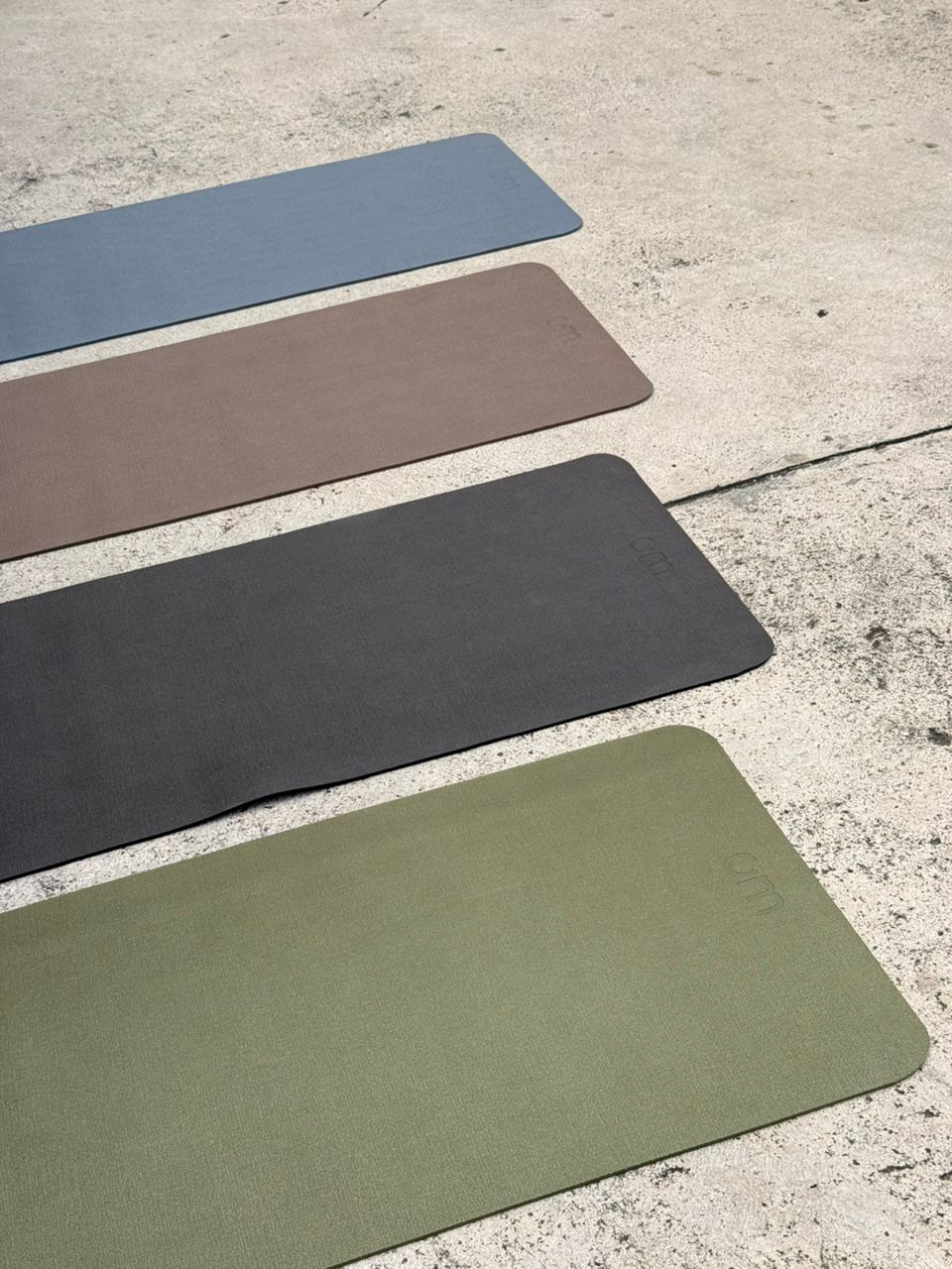 Cuatro mats OM FLOW sobre piso de concreto